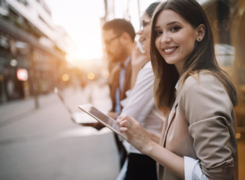 A young professional woman checks her work tablet.
