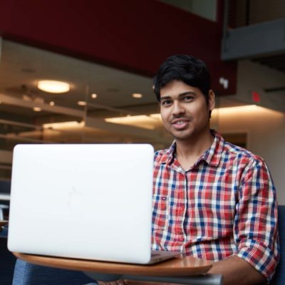 Male international student studies at his laptop