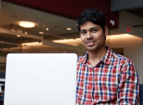 Male international student studies at his laptop