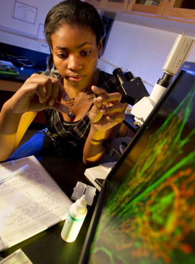 Female science student prepares a slide for the microscope