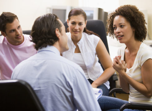 A counselor leads a group therapy session.
