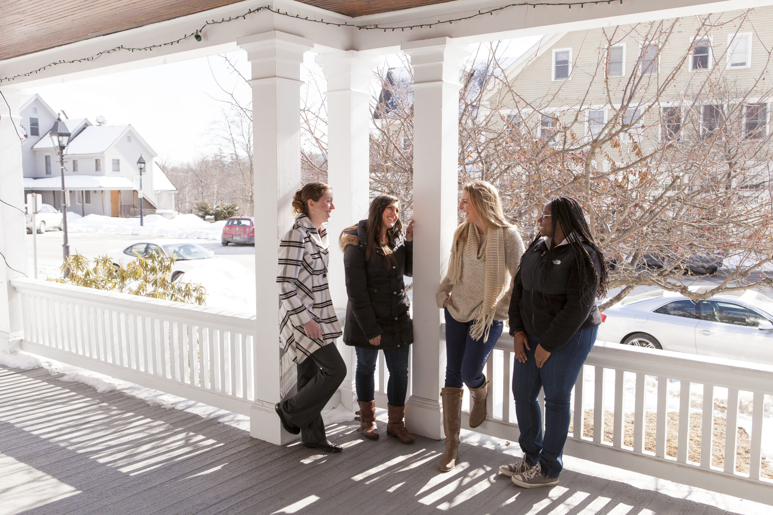 Students on the porch of the Administration Building on NEC's Henniker campus