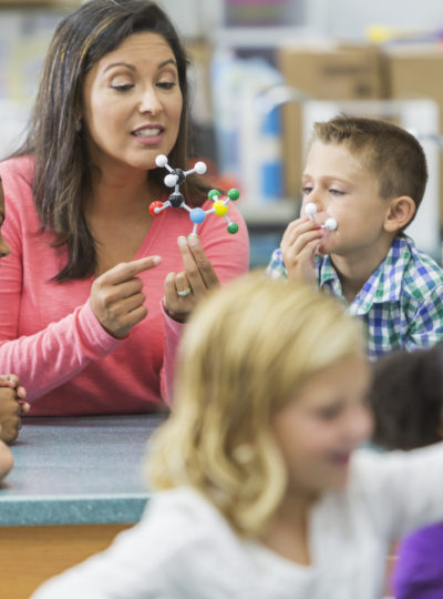 Young woman teaches elementary students about science