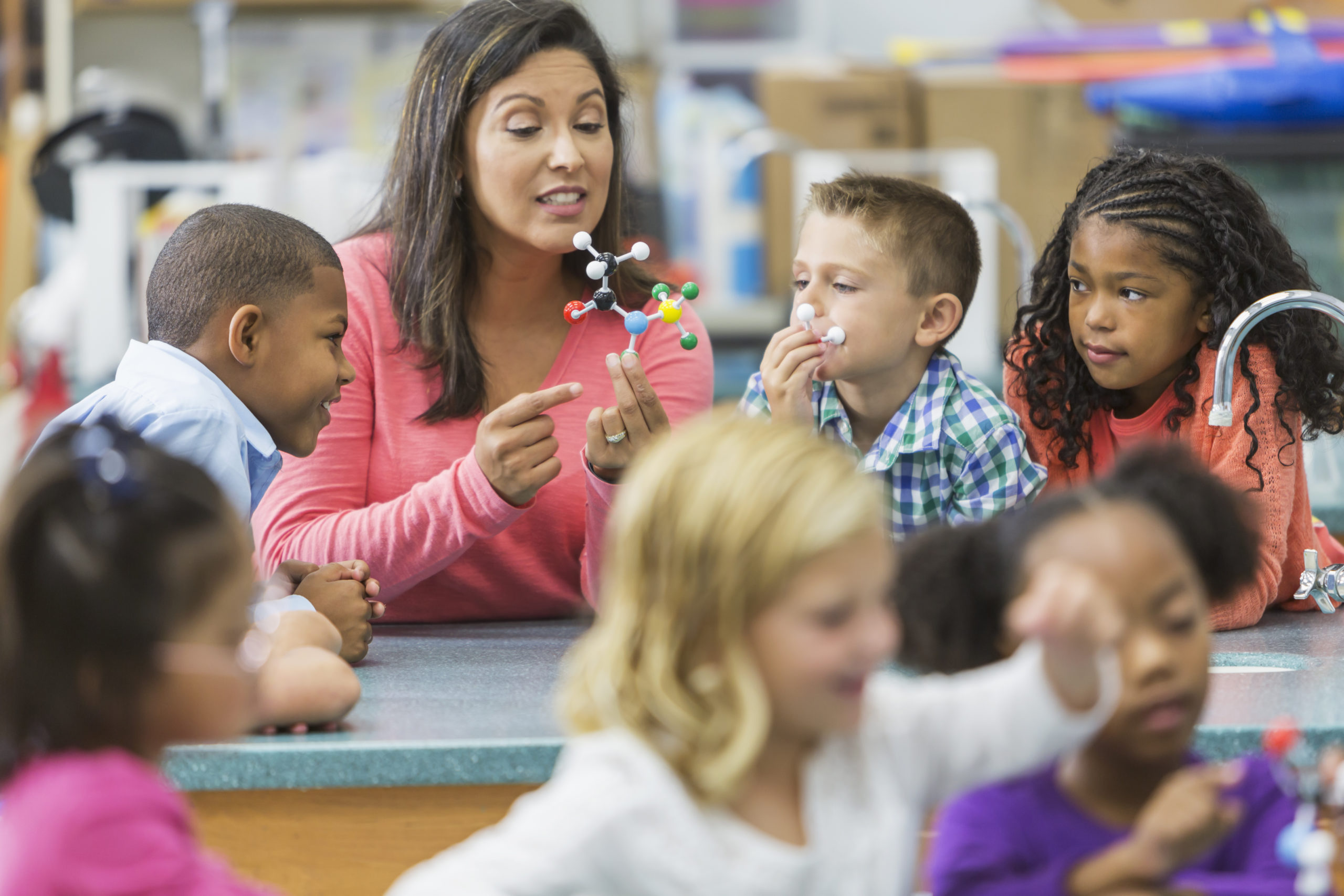 Young woman teaches elementary students about science