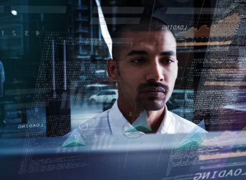 Young computer programmer looking at data