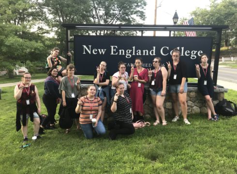 Students in front of NEC sign in Henniker