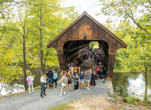 Students crossing covered bridge at convocation