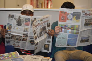 Students reading The NewEnglander, New England College's student-run newspaper