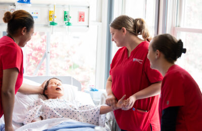 Nursing students at New England College practice their bedside nursing skills.