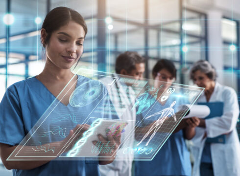 A nurse uses health informatics to deliver patient care.