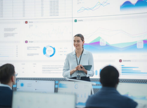 Female data analyst reviews information with her work team.