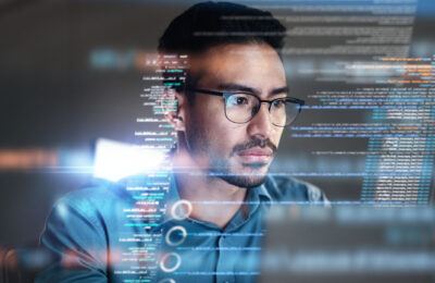 Male information technology and cybersecurity professional works at his computer.