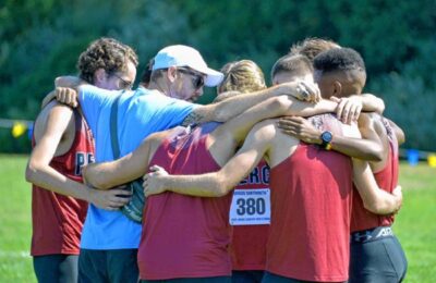 Zach Emerson, the new head coach of track and field at New England College, with a group of runners in Hopkinton, New Hampshire