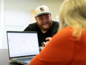 Student at New England College sits with a mentor as part of the College's add-on Mentoring program.
