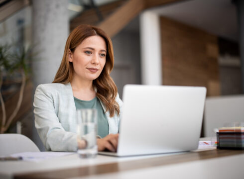 Professional sitting and working on a laptop.
