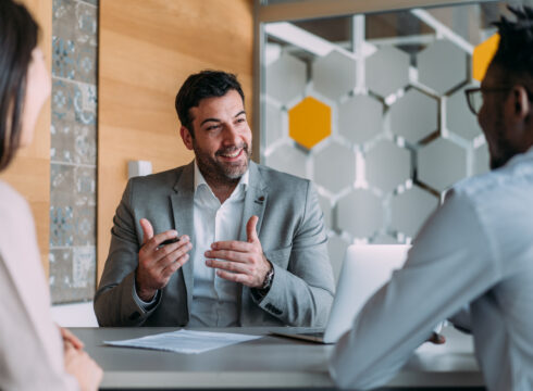 A marketing manager talks with marketing team members.