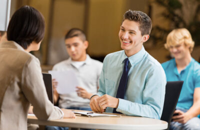 College students attend a career fair and speak with potential employers.