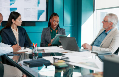 Executives meet around a conference table.